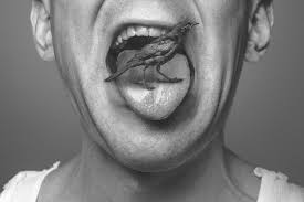 hombre con lqa boca abierta y lengua sacada y en la boca un extraño pájaro