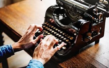 manos sobre maquina de escribir antigua